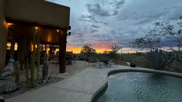 Une terrasse avec une piscine, des sièges d’extérieur et des cactus.