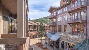 A multi-story building with balconies, a central courtyard with seating, and a sign for 'Copper Lane'. - Timber Creek 309 1 Bedroom Condo (Truckee)