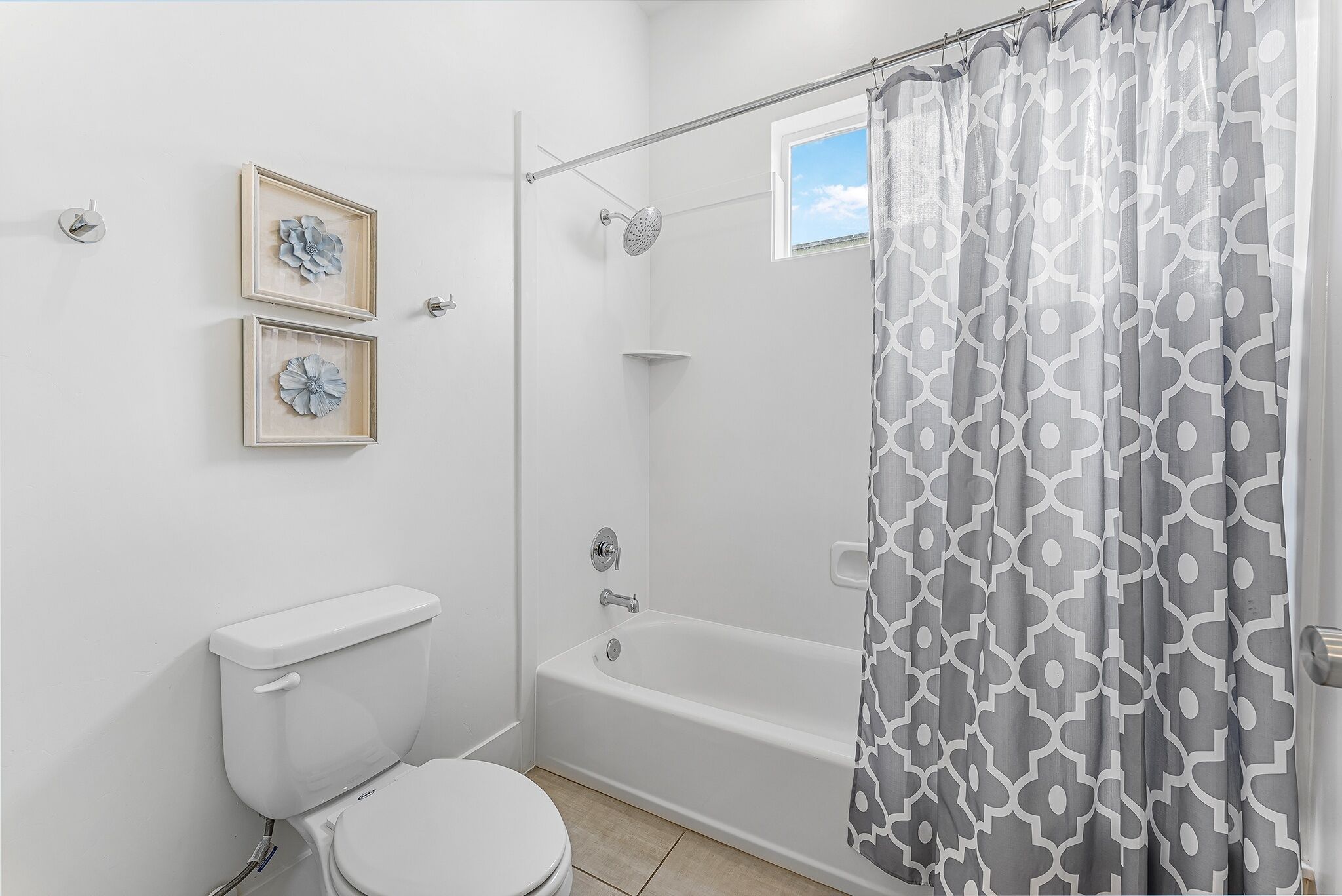A bathroom with a toilet, a bathtub, and a shower curtain.