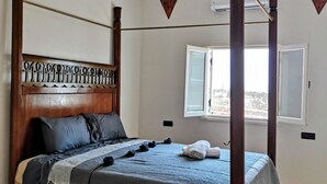 Een hemelbed met een bloemenprintdeken en een decoratief plafond.
