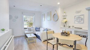 Una sala de estar moderna con un sofá, una mesa de centro y una zona de comedor con sillas y una mesa.