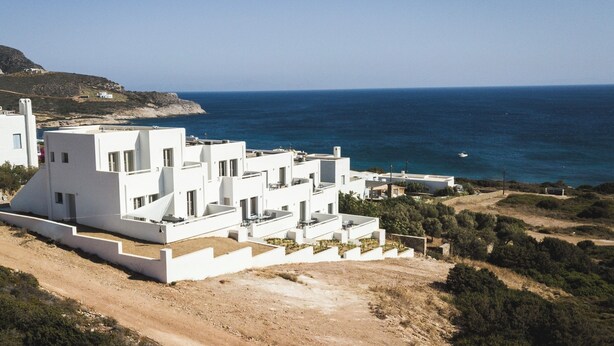 Un edificio blanco con varias terrazas que dan a la costa.