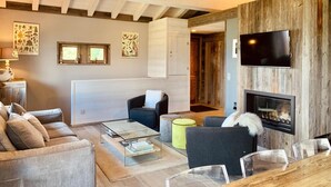 A modern living room with a fireplace, a television, and a cozy seating area.