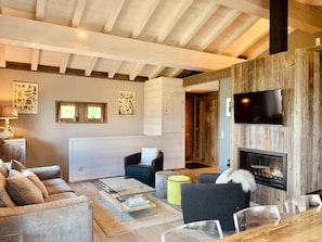 A modern living room with a fireplace, a television, and a cozy seating area.