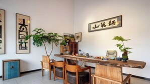 Un comedor con una mesa de madera, cuatro sillas y una planta en maceta.