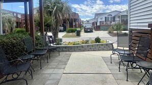 A patio area with outdoor seating, a view of a residential street, and a clear blue sky. - 1560 Mason Circle located in The Keys (Surfside Beach)