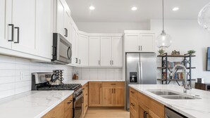 A modern kitchen with white cabinets, a stainless steel refrigerator, and a double sink. - Villa #13 at Bloomington Country Club: Pool, Golf, Restaurant (St. George)