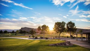 A golf course with a well-maintained lawn, a putting green, and a pavilion. - Villa #18 Bloomington Country Club: Pool, Golf, Restaurant (St. George)