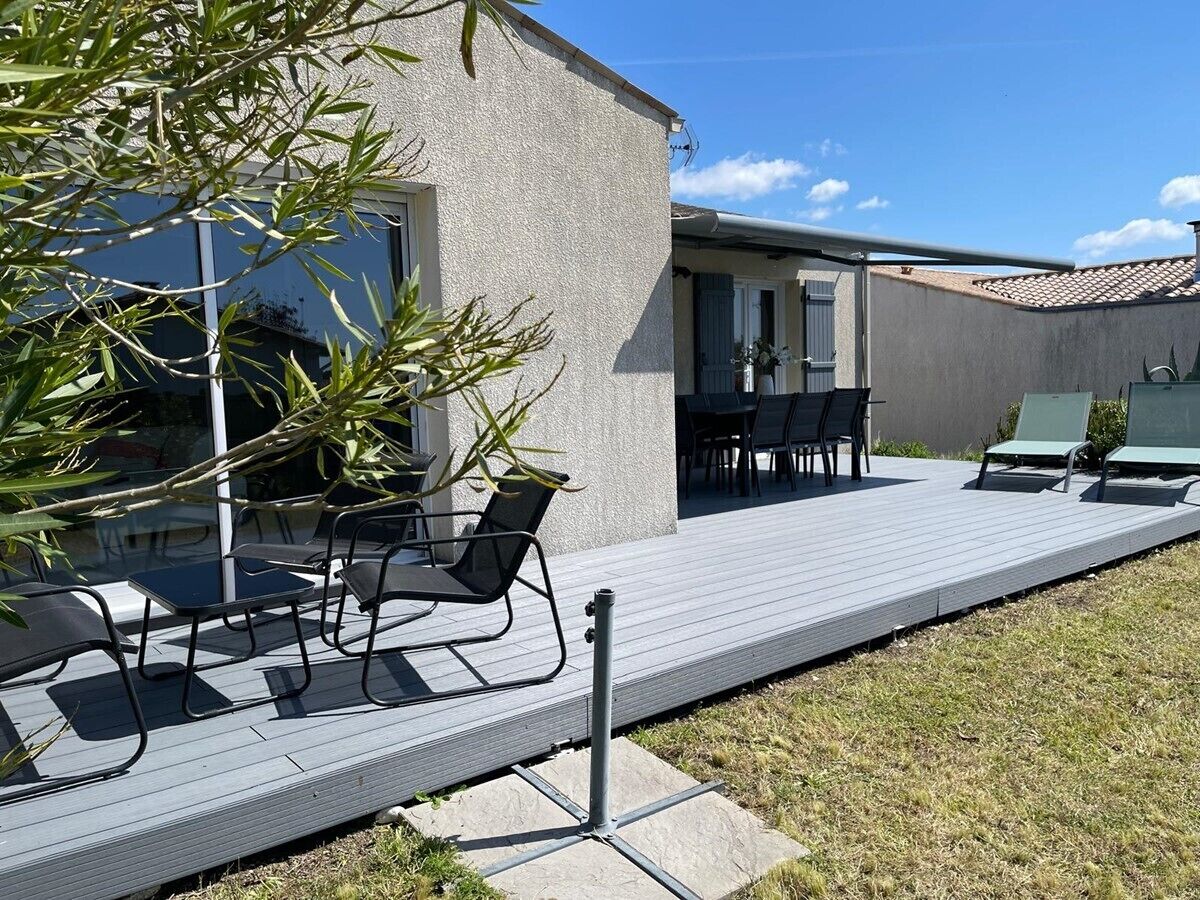 Un patio moderno al aire libre con una zona de estar, una mesita y una silla.