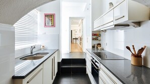 Una cucina moderna con mobili bianchi, piani di lavoro neri e un'isola centrale.