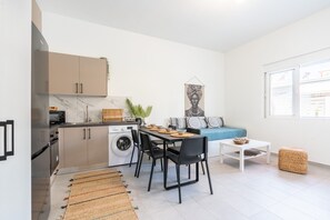 A compact living space with a kitchenette, dining area, and seating area.