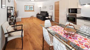A modern apartment with a dining area, kitchen, living room, and a small balcony. - Apartment 'Appartamento Rododendro' with Mountain View, Private Terrace and Wi-Fi (San Tomaso Agordino)