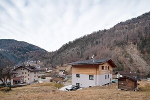 Un village de montagne avec des maisons en bois, un petit chalet en bois et une route pavée.