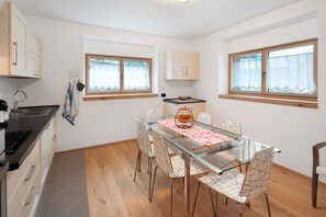 Une cuisine moderne avec un coin repas, des meubles en bois, un évier et une fenêtre donnant sur un paysage agréable.
