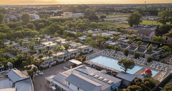 A residential area with multiple small houses, a swimming pool, and a tennis court. - Club Del Sole Adriatico Cervia Easy Camping Village (Cervia)