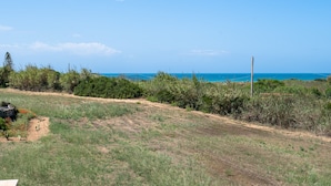 A grassy field with a fence, a power line, and a clear blue sky. - Villa 'Con Tre Camere Da Letto' with Private Terrace, Shared Garden and Air Conditioning (Pachino)