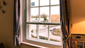 A window with a view of a parking lot and buildings outside. - 7 Domus House Studio Apartment -  a studio that sleeps 2 guests  in 1 bedroom (Chester)