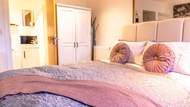 A bedroom with a bed, a wardrobe, and a bathroom visible through an open door. - 7 Domus House Studio Apartment -  a studio that sleeps 2 guests  in 1 bedroom (Chester)