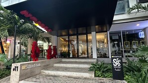 A modern building with a rooftop terrace, a staircase leading to the entrance, and a sign indicating 'Smart Studio Rooftop'.