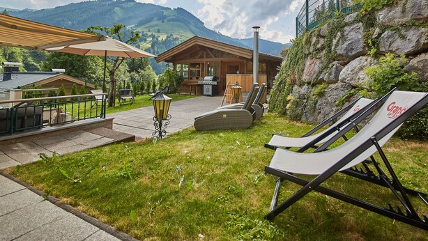Un patio con posti a sedere all'aperto, un'area barbecue e vista sulle montagne.