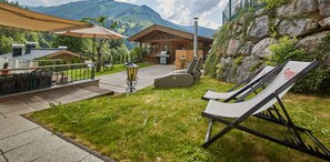 A patio with outdoor seating, a barbecue area, and a view of mountains. - Frei & Wild by we rent (Viehhofen)