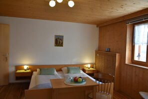 A room with a bed, two bedside tables with lamps, a small table with fruit, a chair, and a window with curtains. - Apartment 'Stark Groß' with Mountain View, Shared Terrace and Wi-Fi (Ciardes)