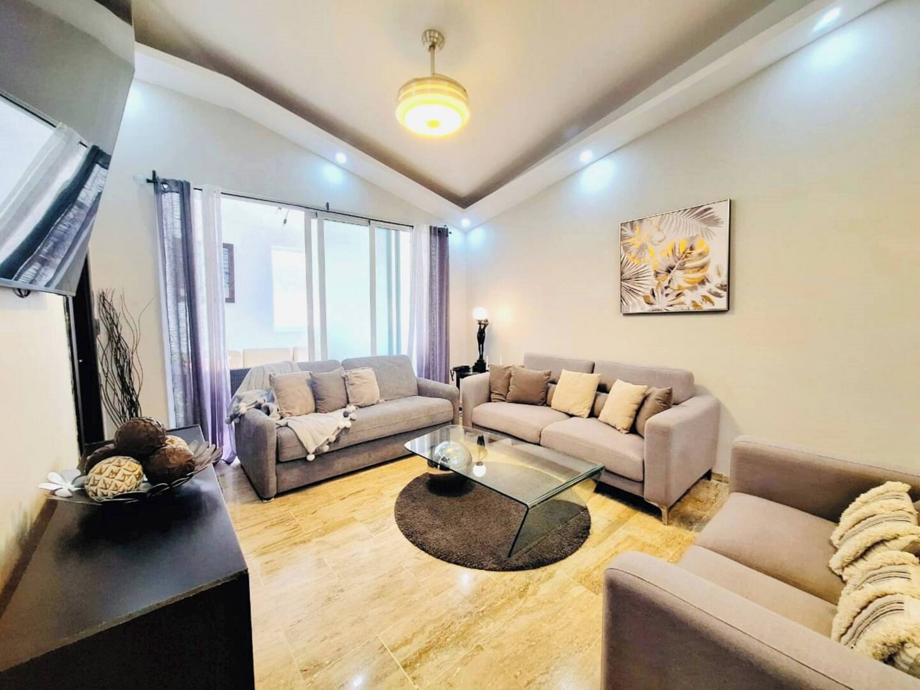 Un salon moderne comprenant un canapé, une table basse et un téléviseur.