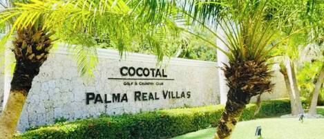 A sign for 'Cocotal Golf & Country Club' with 'Palma Real Villas' written below it.