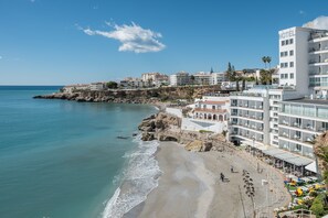 A coastal hotel with multiple floors, balconies, and a beachside location.
