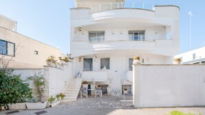A multi-story white building with balconies, a staircase, and potted plants. - Holiday Home 'Le Terrazze Otranto 2' with Shared Terrace, Wi-Fi and Air Conditioning (Otranto)