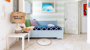A room with a bed, a small table, a lamp, a framed picture, and a door. - Holiday Home 'Le Terrazze Otranto 2' with Shared Terrace, Wi-Fi and Air Conditioning (Otranto)
