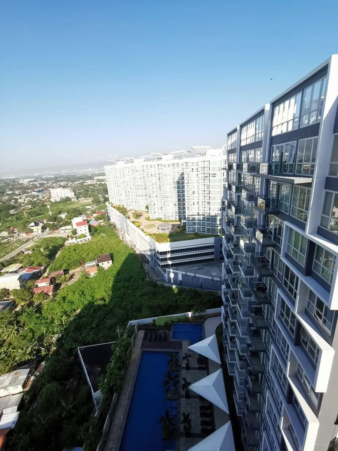 Um edifício alto com várias varandas e área de piscina.