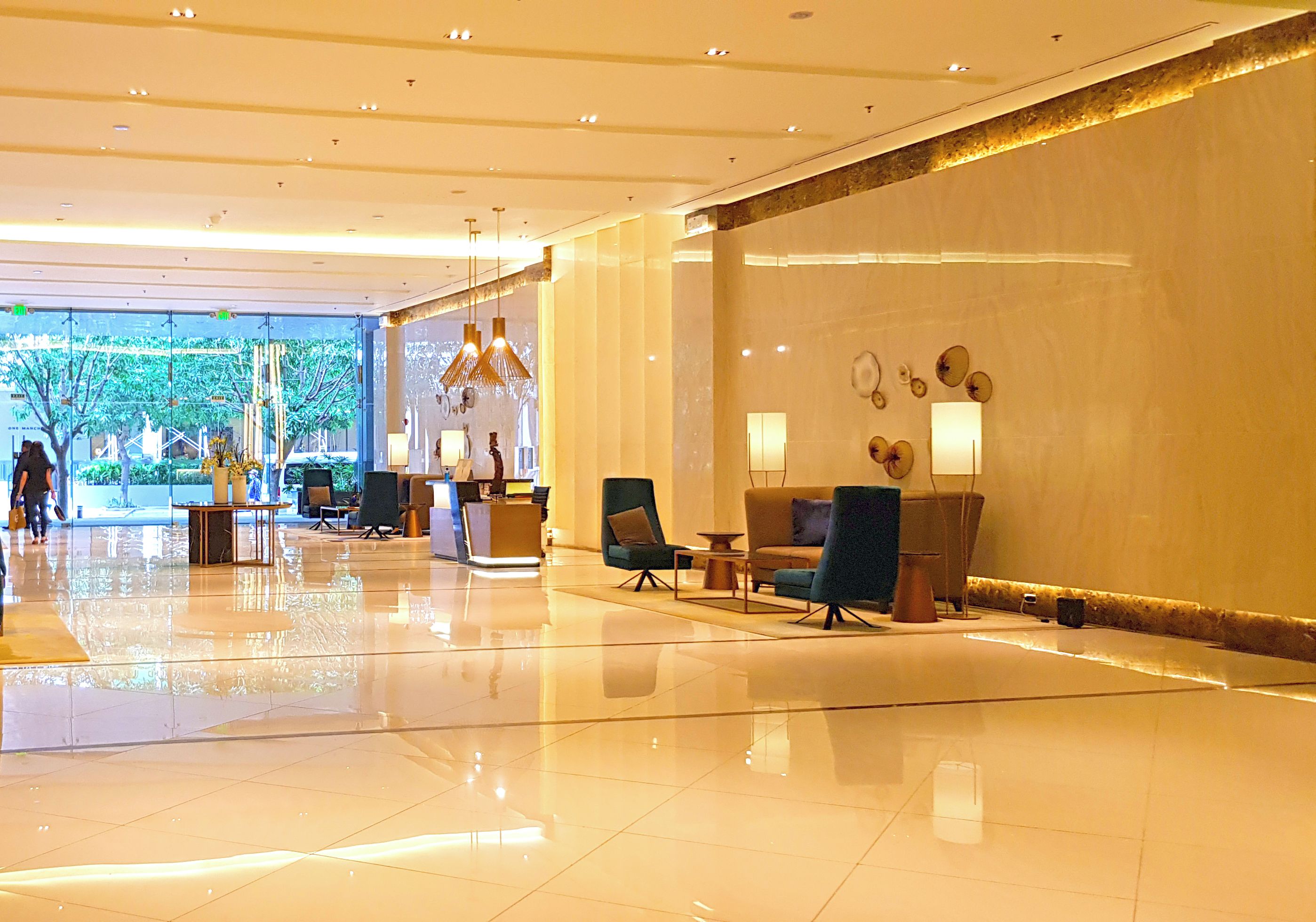A spacious lobby with a polished floor, seating areas, and a reception desk.