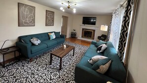 A living room with a sofa set, a coffee table, a fireplace, and a TV mounted on the wall. - Hidden Gem Quiet Dead-End St Near All Casino (Montville)