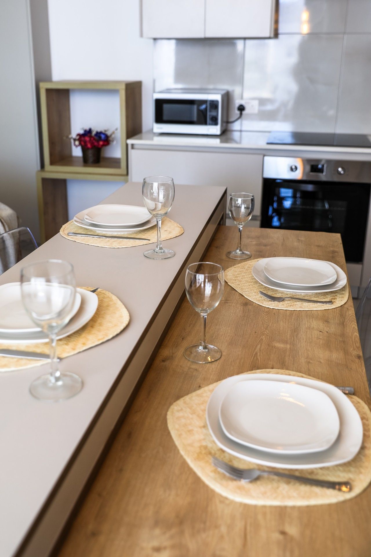 A modern kitchen with a long dining table set for a meal.