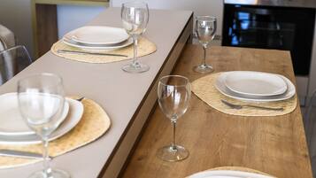 A modern kitchen with a long dining table set for a meal.