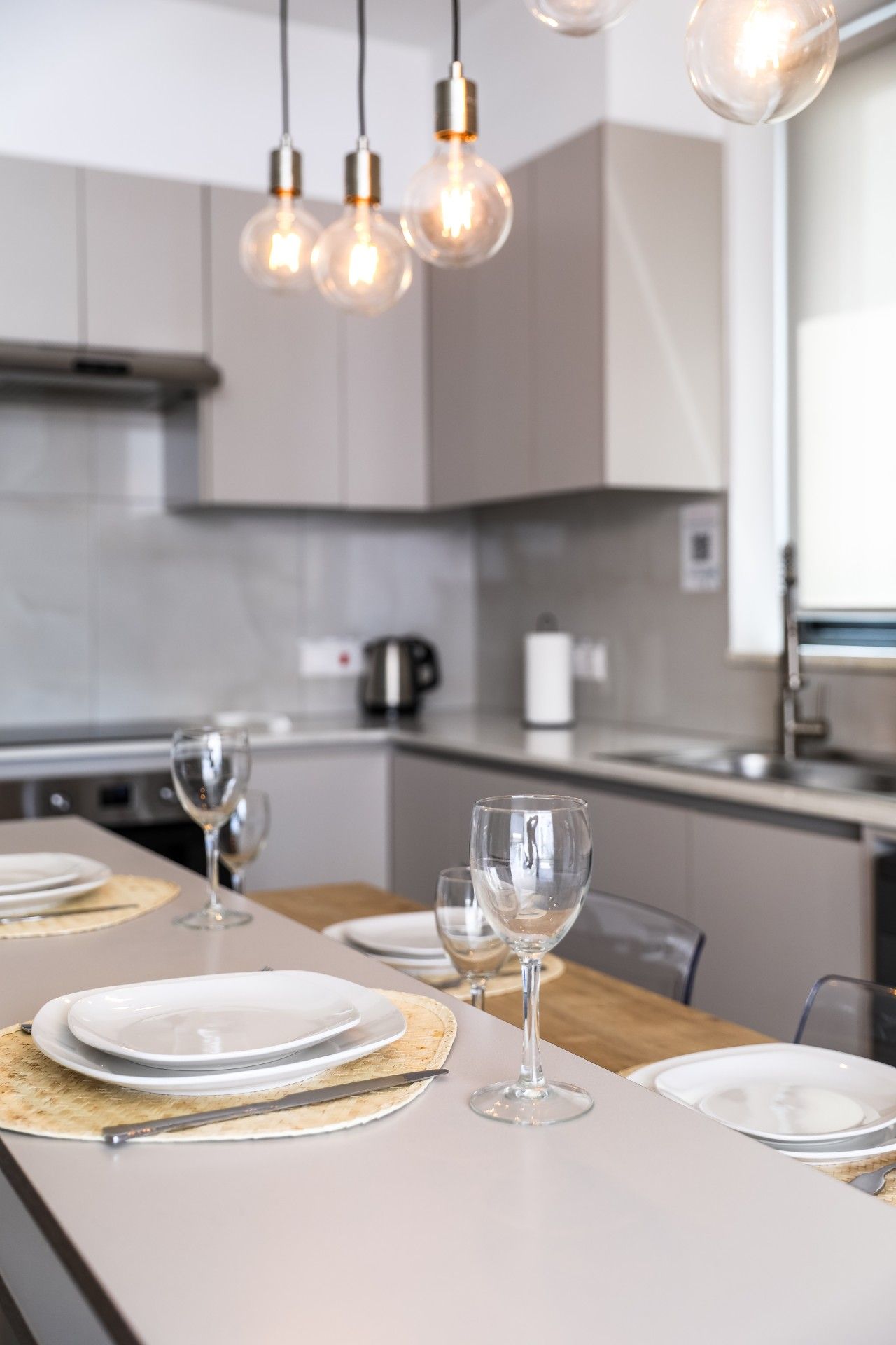 A modern kitchen with a dining area set for a meal.