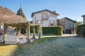 A two-story house with a stone facade, a balcony, and a well-maintained lawn. - Apartment 'Taverna Relax Sara' with Mountain View, Private Terrace and Wi-Fi (Triangia)