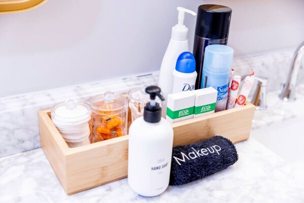 A wooden makeup organizer with various toiletries including a bottle of Dove soap, a blue bottle, and a black container.
