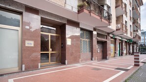 A building with numbered doors, a visible entrance, and a clear pedestrian pathway.