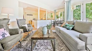 A modern living room with grey sofas, a coffee table, and a dining area with a table and chairs. - Last Minute Deals/A/C/Hot Tub/Great Family Home (La Jolla)