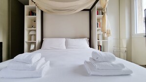 A neatly made bed with white linens and two folded towels on either side. - Italianway - Venini 16 (Milan)