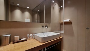 A modern bathroom with a large mirror, a white sink, and a shower area. - Italianway - Venini 16 (Milan)