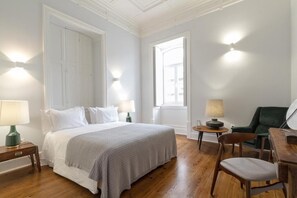 Relax in a stylishly furnished room with a large bed, two bedside lamps, and a comfortable chair.