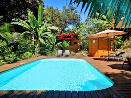 Una piscina al aire libre, sombrillas, tumbonas