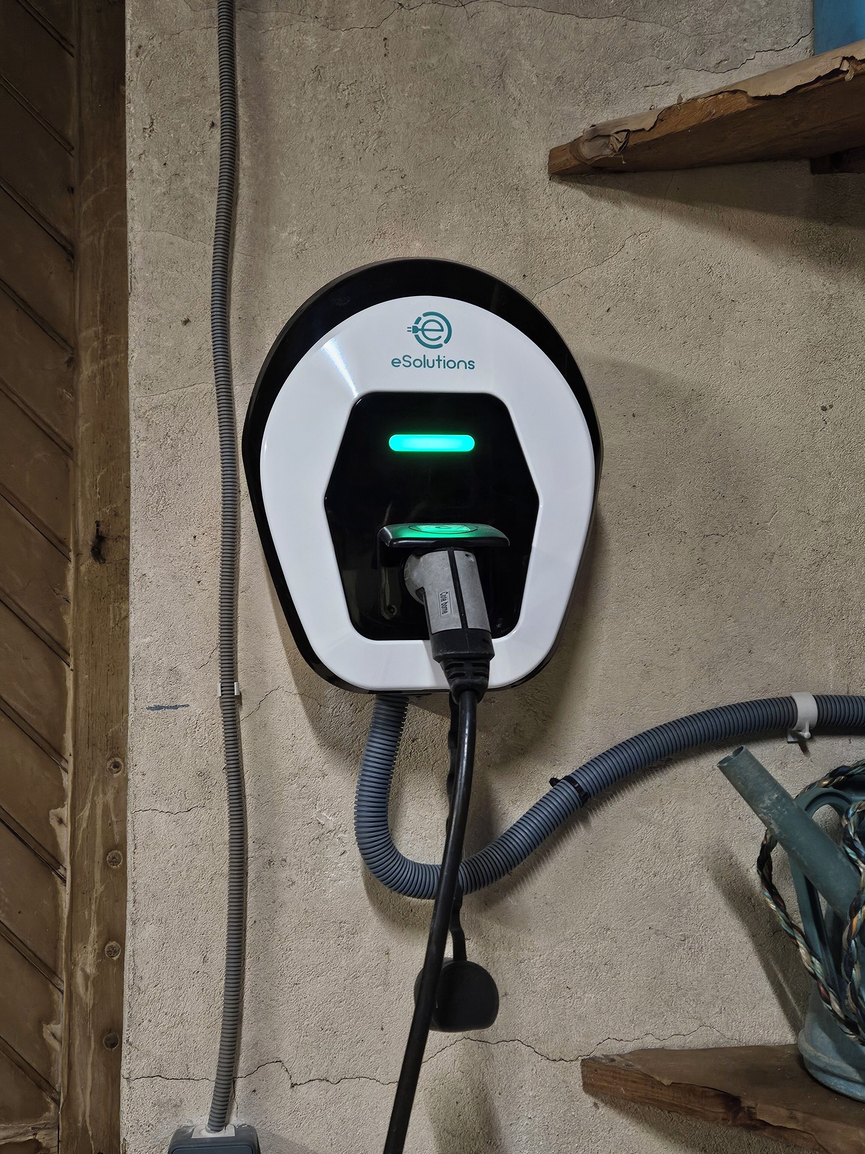 An eSolutions electric vehicle charging station mounted on a concrete wall.