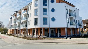 A multi-story residential building with balconies, a central entrance, and a curved facade. - * * * * * * Penthouse Meeresleuchten Duhner Entrée 19 (Cuxhaven)