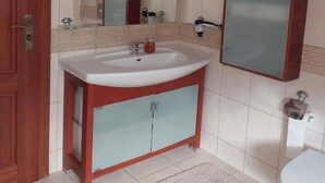 A bathroom with a white sink, a mirror, and a toilet. - Apartment in Sopot near Monte Cassino Street (Sopot)