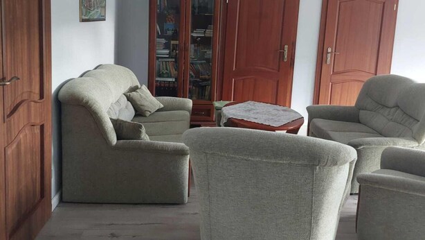 A living room with a sofa, armchairs, a coffee table, and a bookshelf. - Apartment in Sopot near Monte Cassino Street (Sopot)