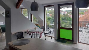 A modern interior with a dining area, a staircase, and a balcony with a view. - Apartment in Sopot near Monte Cassino Street (Sopot)